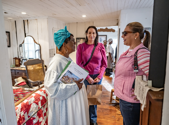 Paulette Taylor, left, a member of the Georgetown Cultural Citizen Memorial Association provides a tour to Elizabeth Sullivan, center, and Remington Smith at the Shotgun House Museum during GeorgetownÕs Art Stroll on Friday, October 16, 2026. The Shotgun House , at 801 West Street, was built between 1920 and 1930. Photo by Andy Sharp