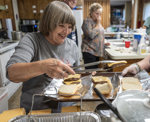 Kathy Boyd prepares hamburger plates during the Third Annual St. Peter Lutheran Church Hamburger Fundraiser on Saturday, October 17, 2026. A Country Store and Quilt Raffle were also held. The church is at 2929 FM 972 in Walburg. Photo by Andy Sharp