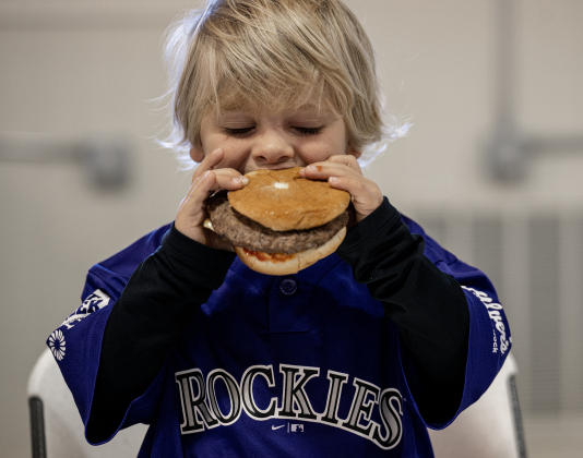 Isaac Makal, 3, enjoys his hamburger during the Third Annual St. Peter Lutheran Church Hamburger Fundraiser on Saturday, October 17, 2026. A Country Store and Quilt Raffle were also held. The church is at 2929 FM 972 in Walburg. Photo by Andy Sharp