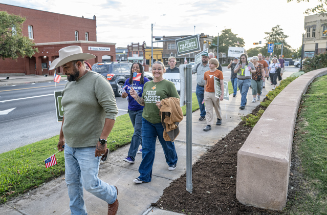 Chris Jimenez, left, running for Texas House District 52 is joined by his wife Katy (behind Chris) and Leslie Booker, back left, running for Judge of the 512thalong as they march along 4th Street toward Taylor City Hall on Monday, October 19, 2026. The event was coordinated by the East Wilco Democrats. Jimenez and his wife Katy cast their ballots. Photo by Andy Sharp