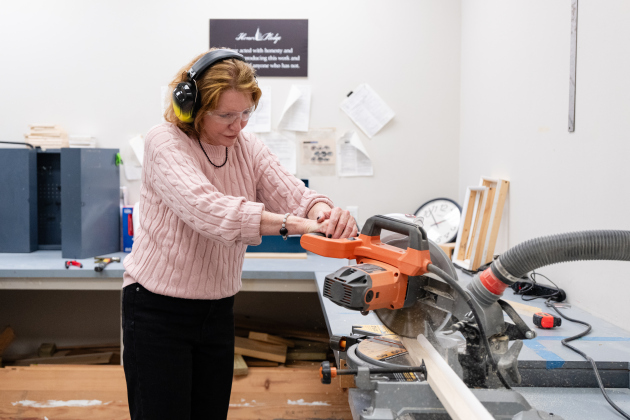 Southwestern University President Laura Skandera Trombley cuts wood to build a canvas as part of following senior Lainie Siegel’s schedule. (Courtesy Southwestern University)