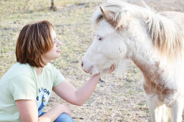 Nonprofit Blue Moon Sanctuary’s founder, Anna Eby, sits with miniature horse Franklin, one of her first rescues. KATHERINE ANTHONY
