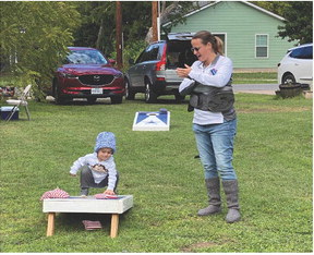 21-month-old Ryker Riley plays cornhold while being cheered on by his mom, Jessice Riley, at the North Old Town Block Party.