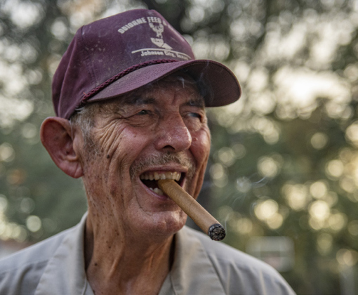 Right, Dennis Jaroszewski enjoys a cigar while assisting in the smoking pit area.