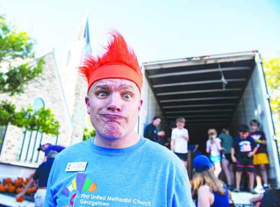 Above, Pastor Alan McGrath was in a festive mood as he helped unload pumpkins.