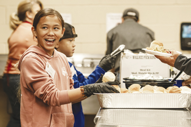 Zoey Toomgem, 11, (front) and her brother Logan, 8, were two of the volunteer helpers distributing meals during the Georgetown Community Thanksgiving, Thursday, November 24, at the Georgetown Community Center in San Gabriel Park.  (Photos by Andy Sharp)