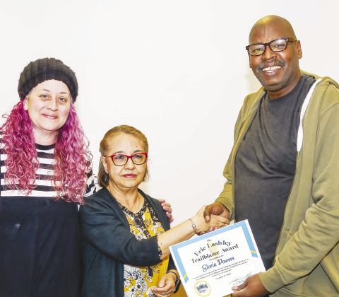 Library employee Powers (center) is congratulated by her supervisor, Kalena Powell, and Friends of the Library President Chuck Collins.