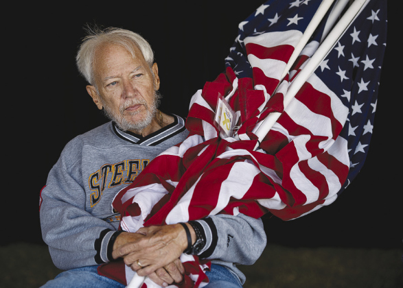 U.S. Army veteran George Stancoven waits to register his five American flags for reposting.