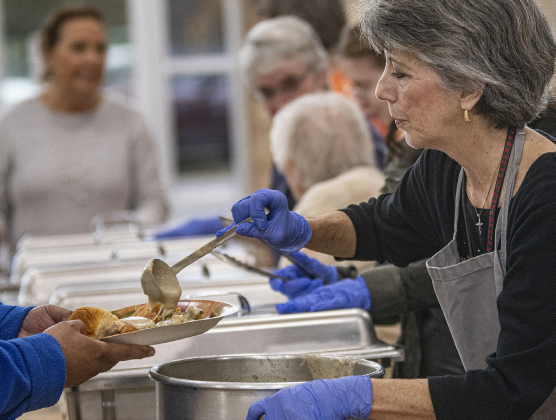 Volunteer Patti Otts of Georgetown serves a meal during Community Thanksgiving in 2019. SUN ARCHIVE