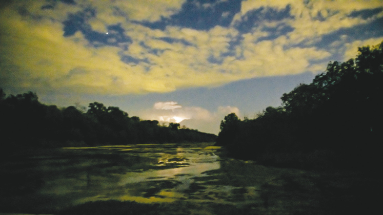 Occasional bits of lightning add light to clouds over the San Gabriel River at Mankin’s Crossing Wednesday.