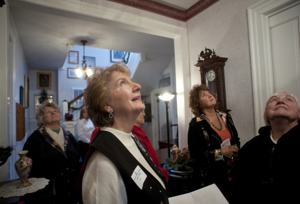 Docent Connie Timko, foreground, directs visitors’ attention to a chandilier in the foyer of the W.C. Vaden Home, one of the historic structures on the Georgetown Heritage Society’s Holiday Homes &amp;amp; Buildings Tour December 14, 2013. SUN ARCHIVE