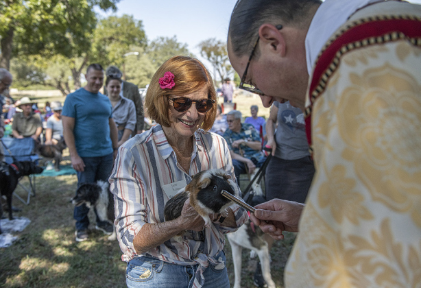 The Reverend Bertie Pearson, rector at Grace Episcopal Church, bestows a blessing on Mr. Nibbles, a guinea pig with Janet Koran.