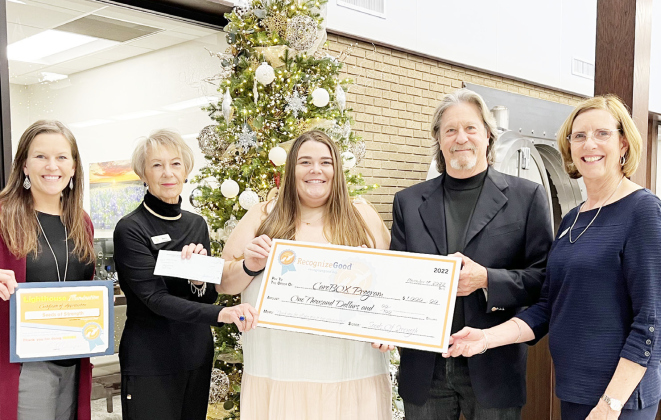 Janelle McNeill, Marsi Liddell, Chandler Stancliff, Bob Blomquist and Pam Carlson gather at First Texas Bank to hand off a $1,000 check for CareBOX Tuesday, November 29.