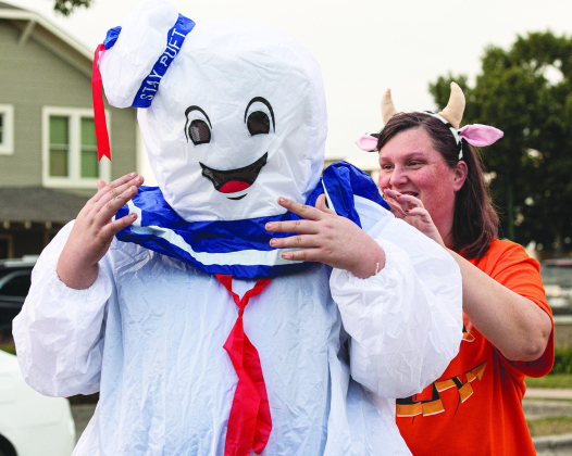 ANDY SHARP Easton Davis, 12, gets some help from his mom Doris Davis with his Ghostbusters Marshmallow Man costume as they get ready to enjoy Halloween night along Main Street in Old Town Monday, October 31. See more on Page 13