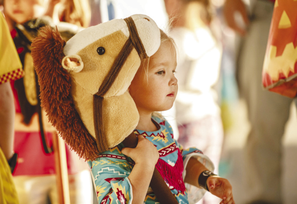 Right, Millie Whitson, 3, holds onto her horse.