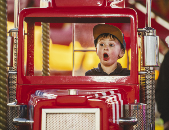 Noah Esparza, 3, has fun on a merry-go-round.