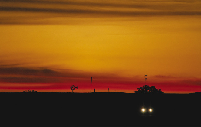 A vehicle makes its way along County Road 327 with western skies filled with subtle color after sunset October 22. — Photos by Andy Sharp