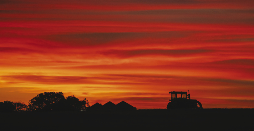 The skies fill with color beyond a tractor along County Road 334 October 22,