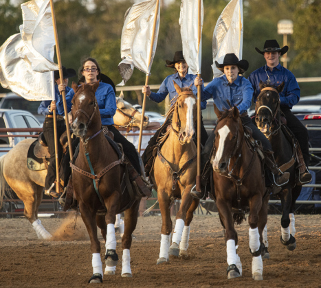 The Clayman Cowgirls Drill Team, joined by Reid Gregory at right, perform.