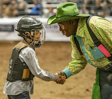 Weston Sartell, 8, is congratulated by longtime rodeo clown Leon Coffee after Weston won the Mutton Bustin’ event.
