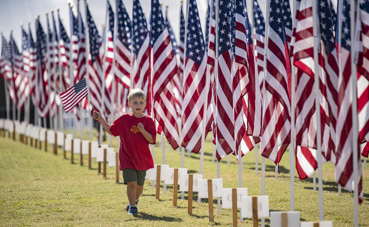 Cipriano Coffey, 5, runs past flags at the Field of Honor while carrying his own American flag Saturday, November 5. His father, William Coffey, is a Marine Corps veteran. The Field of Honor, sponsored by the Rotary Club of Georgetown, will be on display at San Gabriel Park throughout the week. See more on photos, schedule on Page 9 and in Salute to Veterans