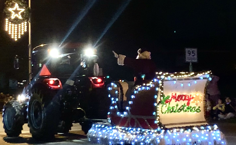 Santa and his sleigh are pulled by a tractor during the Christmas Lights Parade, hosted by the Taylor Area Ministerial Alliance. (Photo by Brigid Cooley)