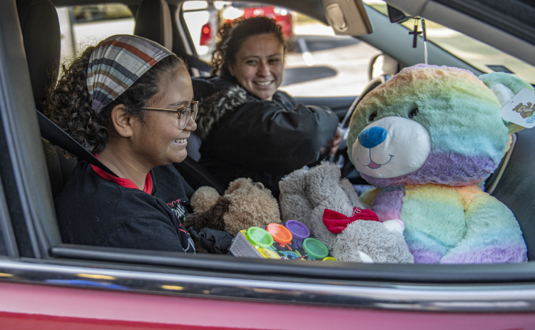 10-year-old Ayva Pereira and her mom Sonia Pereira were very happy with their gift boxes and big stuffed animals during the Georgetown Police Department's Blue Santa distribution, held at the Georgetown Public Safety headquarters on Saturday, December 17.   Volunteers gave out gift boxes for 2235 children and over 700 pre-qualified  families this year.  Georgetown's Blue Santa program began in 2005. (Photo by Andy Sharp)