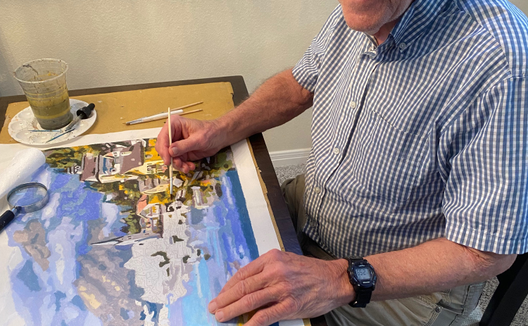 With a look of joy, George Egbert paints his latest canvas.  (PHOTOS BY ELLEN GREENEY)