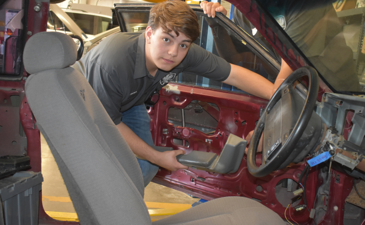 Georgetown High School junior Michael Friemel stands with a reworked 1992 Ford Fox Body Mustang, now an electric car. (Photo by Katherine Anthony)