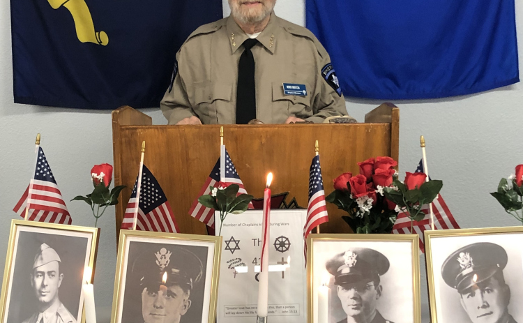Post Chaplain Michael Meccia opens the Four Chaplains Memorial Service held January 21. On the table in front of the podium are photos of the four chaplains being remembered, Lieutenants George L. Fox, Alexander D. Goode, John P. Washington and Clark V. Poling.