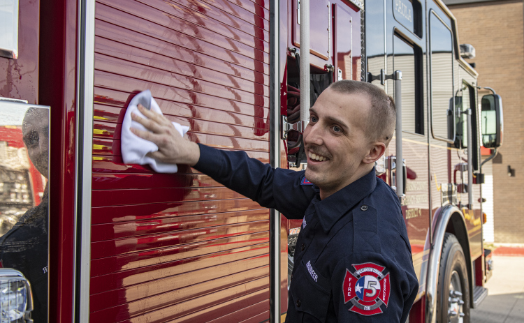 Jarrell firefighter Jake Owen helps with a ceremonial cleaning of his department's new ladder truck February 17. Mr. Owen, 24, is undergoing treatment for brain cancer and had returned to the department for the first time since starting treatments in January. Photo by Andy Sharp