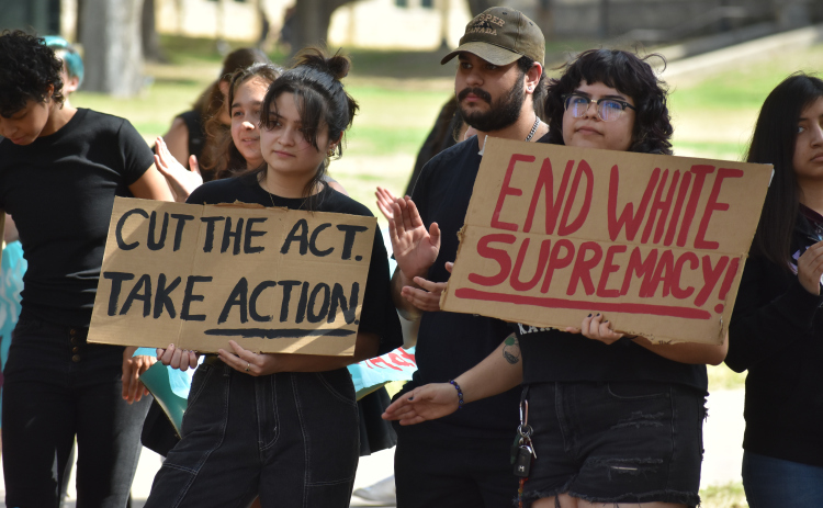 Southwestern University students hold signs that read "End white supremacy" and "Cut the act. Take Action," at a protest Wednesday, February 22. Photo by Katherine Anthony