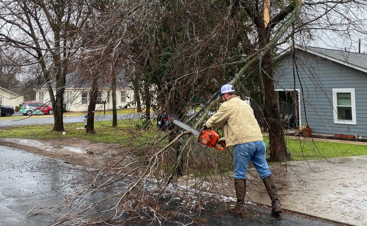 , District 6 Council Member Jake French cuts a tree in North Old Town the week of the storm. (Photo courtesy Jen Bradac)