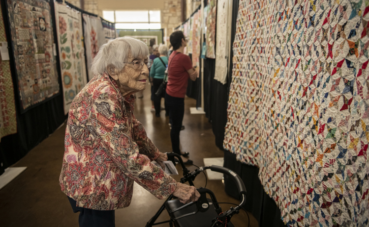 JoAnn Hammer admires a quilt made in 1940 entitled "Starry Night"  on Saturday, March 25, at the annual Georgetown Quilt Show, presented by Handcrafts Unlimited.