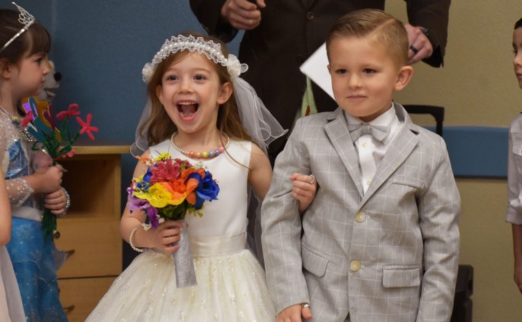 Bride U and Groom Q, Pre-K students Frances Averitt and Axel Lundgren, walk down the aisle after their educational pretend wedding ceremony. Photos by Katherine Anthony