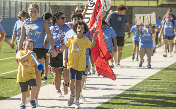6-year-old Tyler Brandon, a student at McCoy Elementary School, blows his blue horn while taking part in the opening parade.