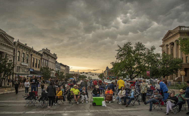 Red Poppy Festival attendees along Austin Avenue wait for the start of a concert  on Friday evening, April 28, 2023.  Rain, accompanied by hail and high winds in some areas, moved through Williamson County throughout the evening.