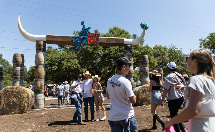 Visitors pose at the entrance of the Two Step Inn Festival April 15.