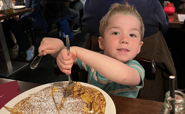 Grandson Simon eats a Dutch pancake in Amsterdam.