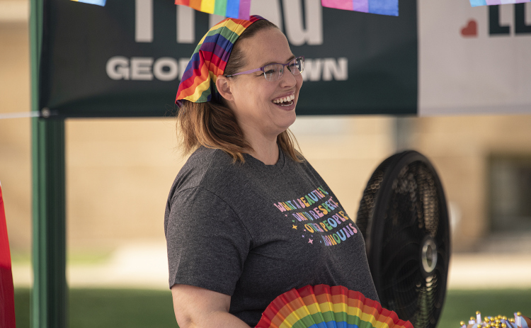 Laura Morgan, with Georgetown PFLAG, was equipped with a hand fan and an electric fan as she stayed cool. The Georgetown PFLAG chapter, established in 2022, was here to answer questions and inform visitors during Pride Month.