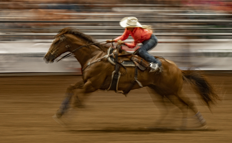 Kathryn Giese of Huntsville, Texas makes a dash across the arena after competing in Barrel Racing.