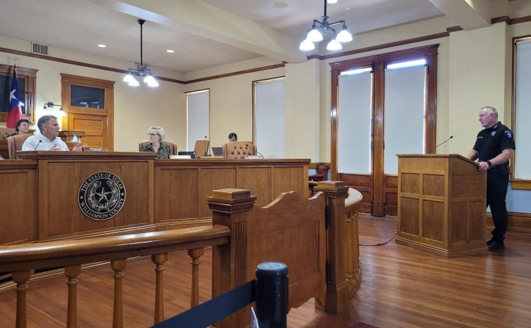 Williamson County Judge Bill Gravell explains his reasoning about grant-funded positions to Williamson County Sheriff Chief Deputy Patrick Erickson during the June 27  commissioners court meeting. Photo by Nalani Nuylan