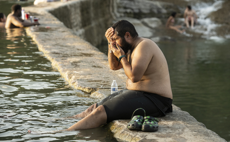 Luis Guillermo Ovalles cools off at Blue Hole Park after completing a  24-mile bicycle ride July 26, 2023.  Sun archive photo