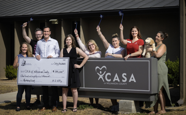W.D. Kelley Foundation Executive Director Carl Illig, center of check, poses with CASA of Williamson County after funding a new marketing coordinator position. Country of CASA of Williamson County.