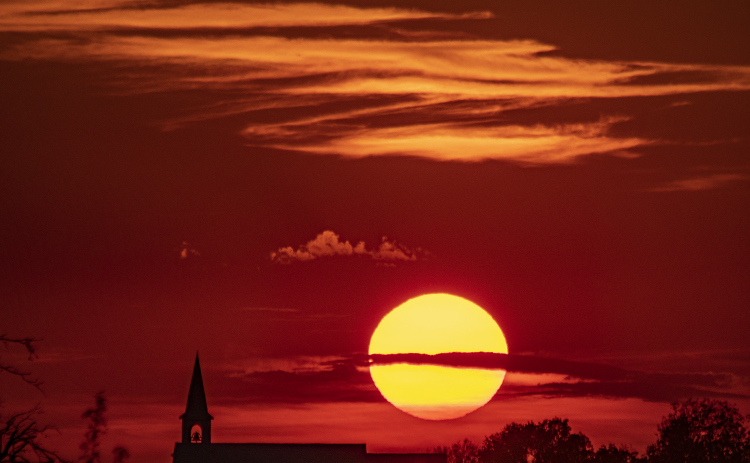 The sun goes down over St. Peter's Church of Coupland on Tuesday, September 26, 2023.  This view is from County Road 460, east of Coupland.