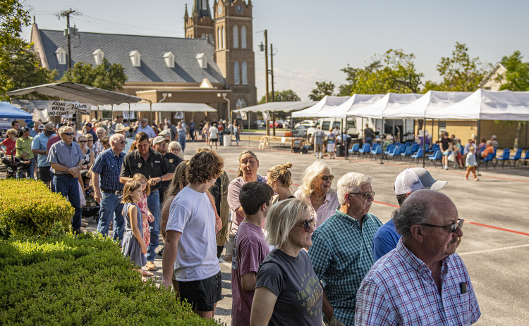 A line of diners forms outside the Parish Activity Center.