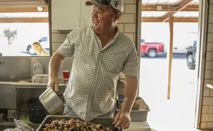 Adam Martinka sorts cubes of brisket in the smoking pit area.