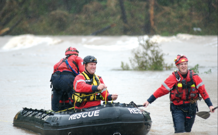 Travis County Emergency Paramedics maneuver a rescue boat in the San Gabriel River off Highway 29 during the 2010 floods. Sun Archive Photo.