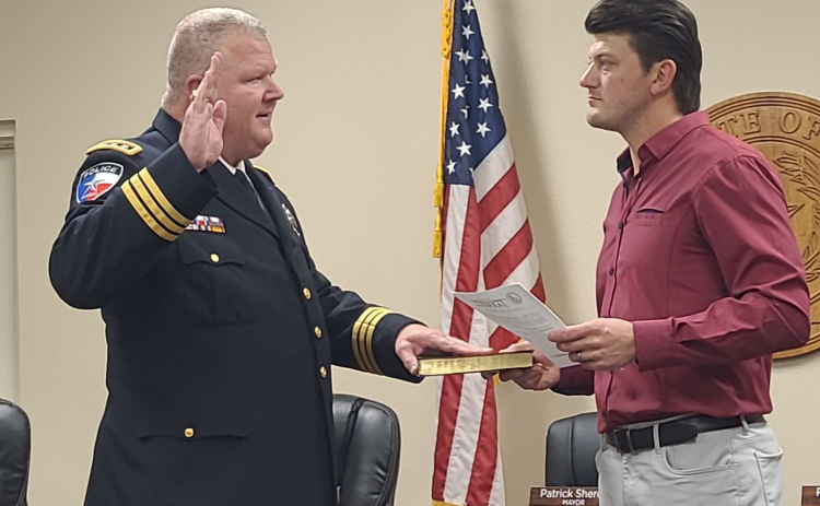 Patrick South, left, takes his oath to be the City of Jarrell’s new police chief at Jarrell’s city hall on October 25.  Photo by Nalani Nuylan.