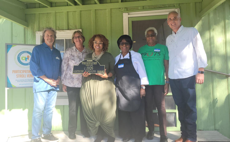 Regina Durden, center, holds the “Gertrude Randolph House” plaque after Preservation Georgetown presented it to the Georgetown Cultural Citizens Memorial Association.